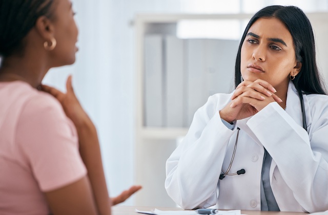 Doctor consulting with a patient about thyroid care, representing the integration of specialized care through Rousia's referral system.