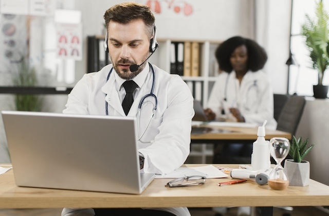 Doctor using a laptop for telehealth consultation, representing the expansion of thyroid care services through Rousia's provider network.